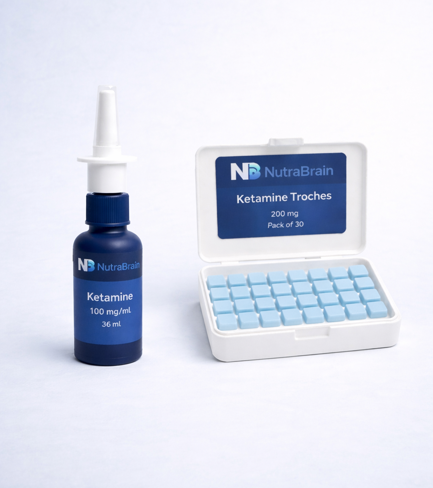 A blue bottle labeled "Ketamine 100 mg/mL" with a nasal spray top stands next to a white box containing thirty blue rectangular tablets labeled "Ketamine Troches 200 mg.