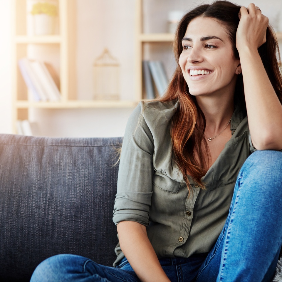 Relax, sofa and woman in home for rest, smile and living room for alone and break on weekend. Happy, calm and day off in apartment for female person, lounge and comfort on couch