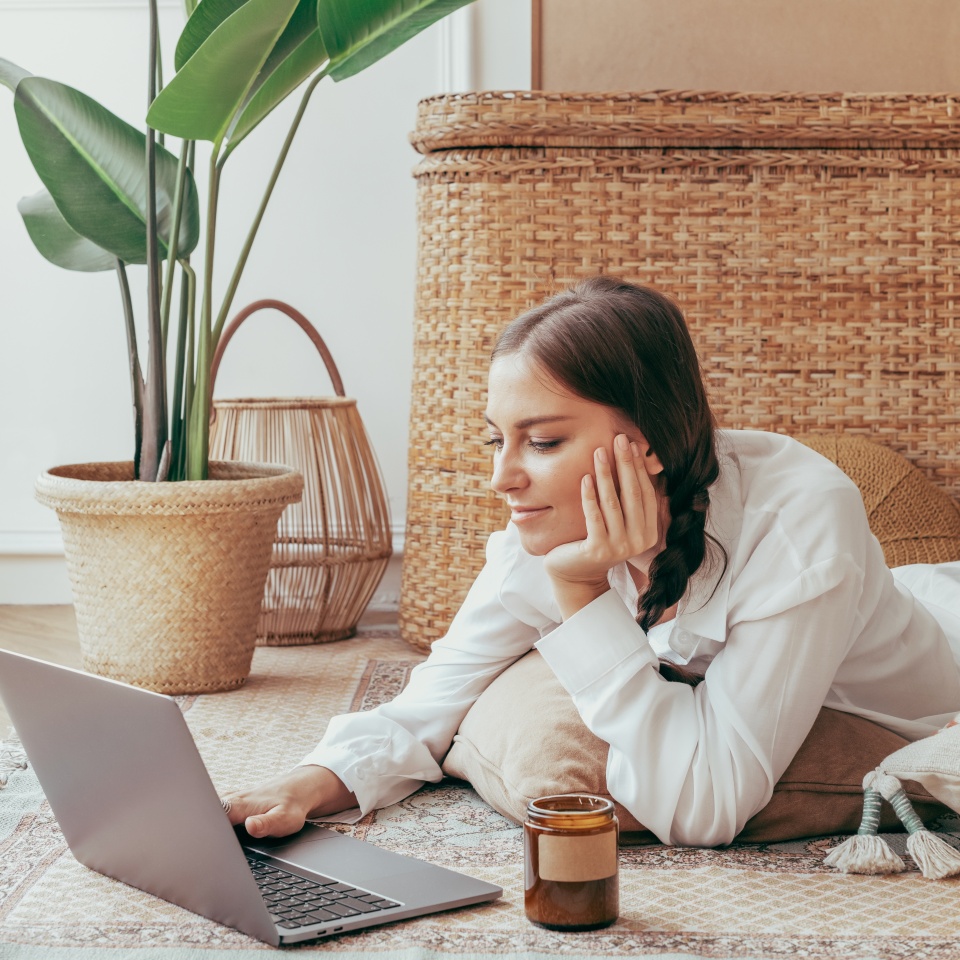 Woman using laptop on the floor. Woman lay chilling on the floor and using tablet at home. Wonman. Woman relaxing at home by using table. Woman relaxing at living room with using laptop.