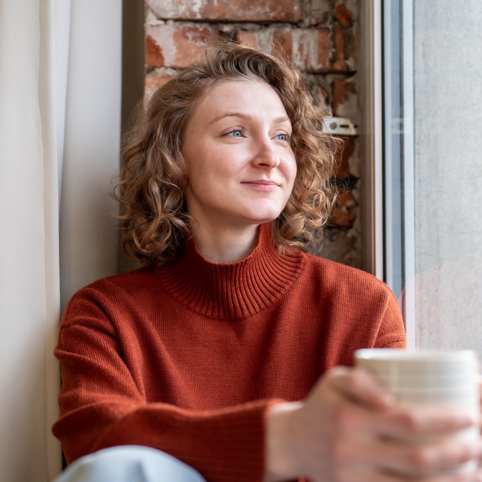 Happy relaxed woman enjoying quiet time simple joys holding coffee mug, lost in positive thoughts. Serene female feels deep inner peace, self-reflection tranquil mood. Calmness, gratitude, contentment