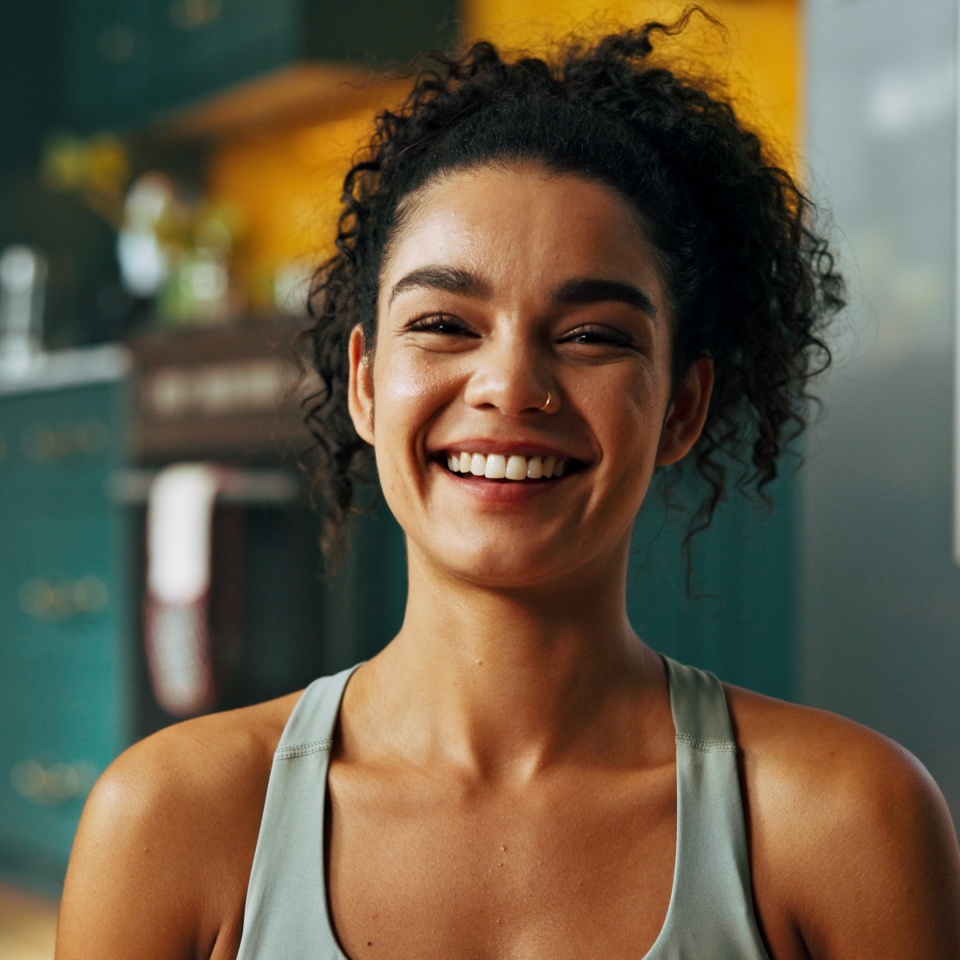 Portrait, woman and fitness at home for health, happiness and positive mood with exercise. Laugh, cheerful and female person with a smile for workout, wellness and stress relief in house or apartment