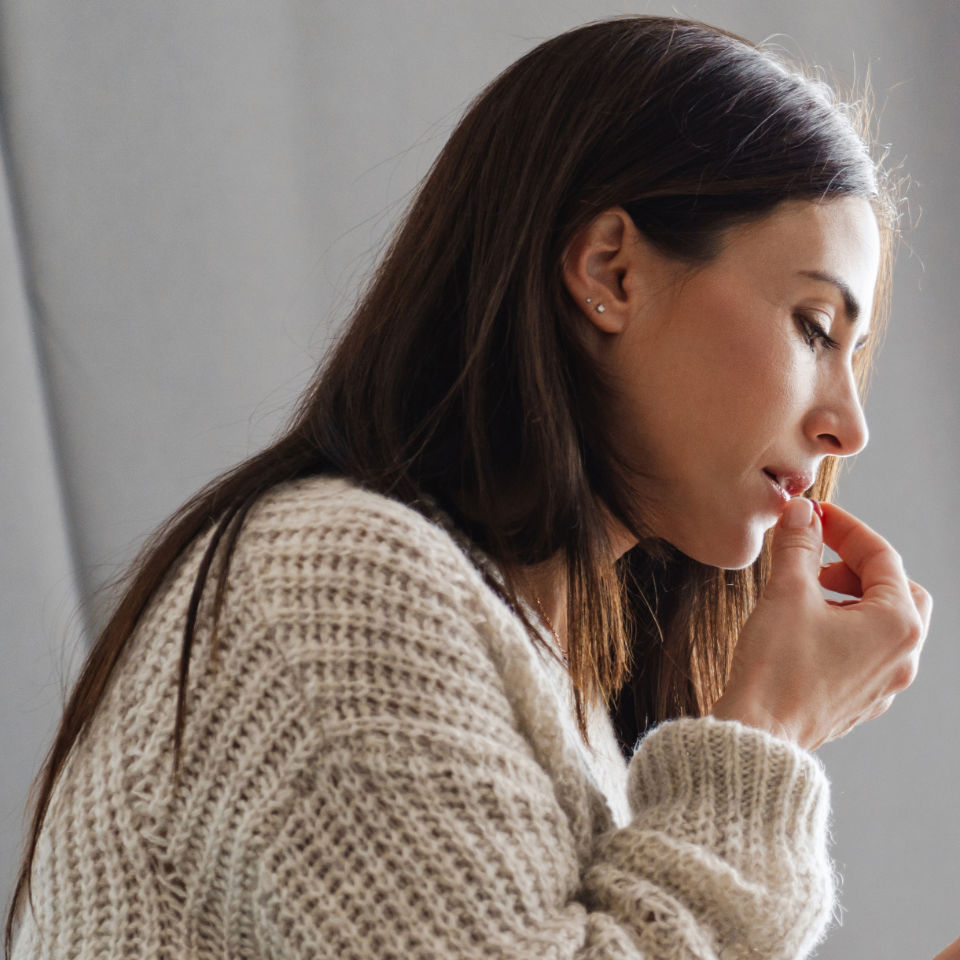 The side view of woman taking a pill